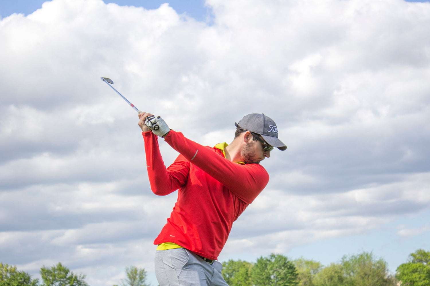 Golfer swinging his iron